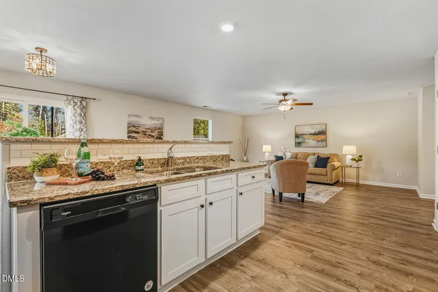 a kitchen with stainless steel appliances granite countertop a stove a sink and white cabinets