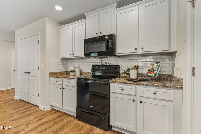 a view of a dining room with furniture a chandelier and wooden floor