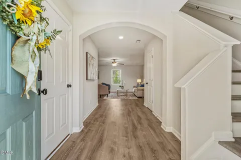 a view of a hallway with wooden floor and staircase