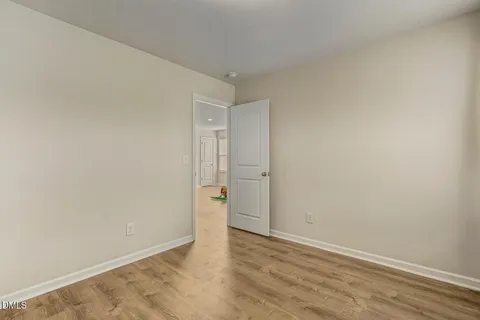 a view of an empty room with closet and a window