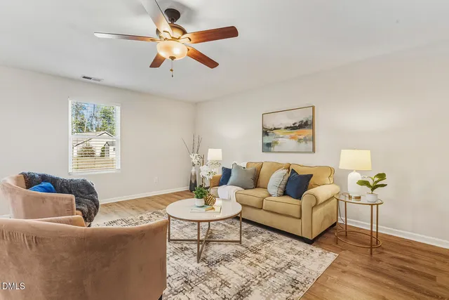 a living room with furniture and a wooden floor