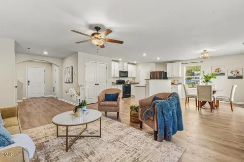 a living room with furniture kitchen view and a table