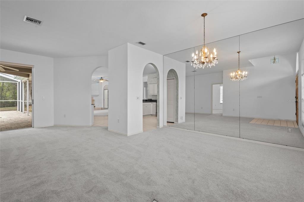 18543 Bittern Avenue Lutz, FL 33558 - Photo 29 of 45 a view of a big room with chandelier and glass door