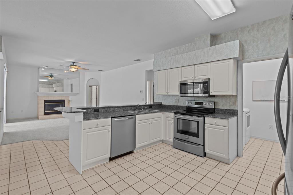 18543 Bittern Avenue Lutz, FL 33558 - Photo 6 of 45 a kitchen with white cabinets appliances and sink