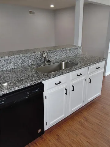 a view with granite countertop cabinets and wooden floor