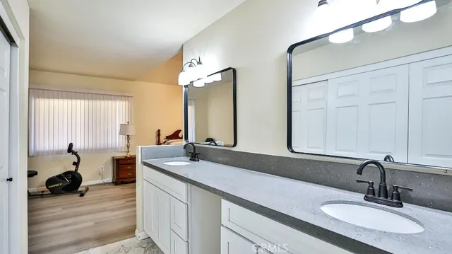 a bathroom with a granite countertop sink a mirror and vanity
