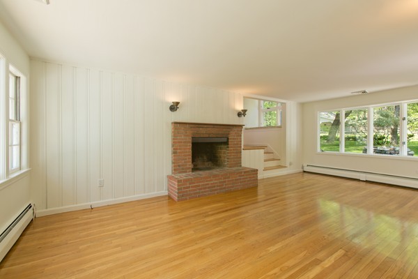 76 Sunset Road Carlisle, MA 01741 - Photo 8 of 29 a view of empty room with wooden floor and fireplace