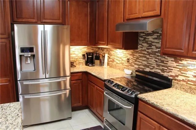 a kitchen with stainless steel appliances granite countertop a refrigerator stove and microwave