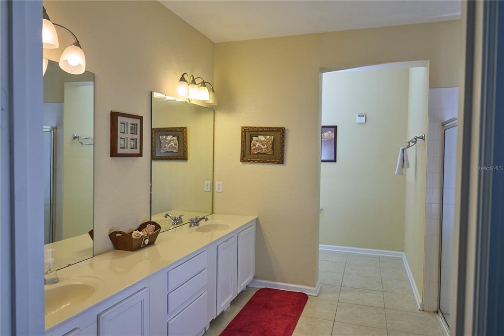 5012 Shoreway Loop, Unit 10407 Orlando, FL 32819 - Photo 19 of 35 a bathroom with a granite countertop sink and a mirror