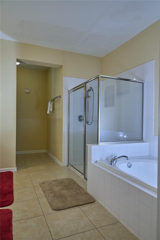5012 Shoreway Loop, Unit 10407 Orlando, FL 32819 - Photo 20 of 35 a bathroom with a tub shower and mirror