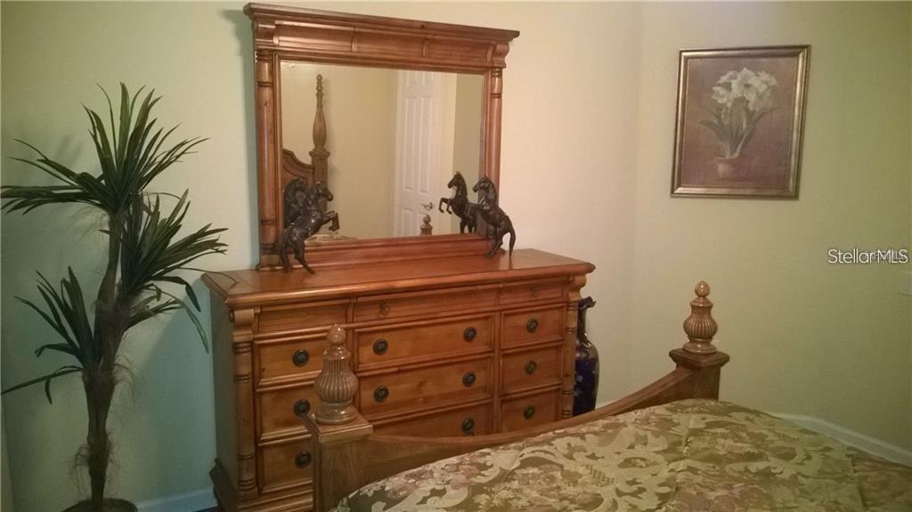 5012 Shoreway Loop, Unit 10407 Orlando, FL 32819 - Photo 21 of 35 a room with a bed and a potted plant