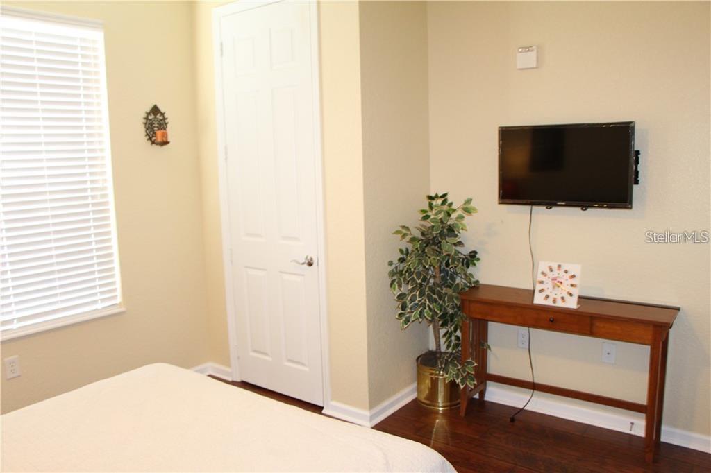 5012 Shoreway Loop, Unit 10407 Orlando, FL 32819 - Photo 24 of 35 a living room with a flat screen tv and a potted plant