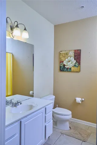 a bathroom with a granite countertop toilet sink and mirror