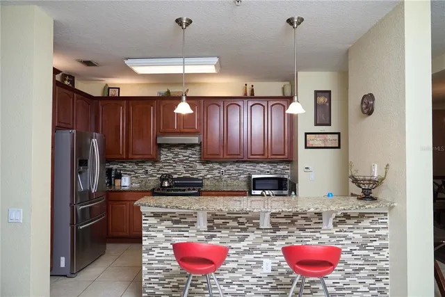 a kitchen with stainless steel appliances granite countertop a stove refrigerator a sink and dishwasher