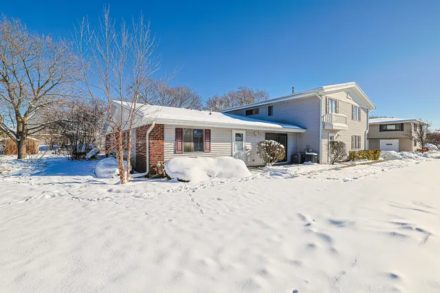 a front view of a house with a yard covered in snow