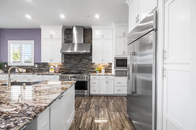 a view of a hallway with wooden floor and a bathroom