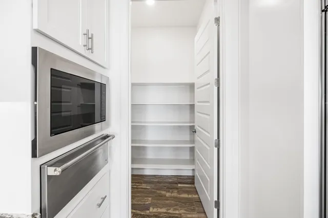 a kitchen with granite countertop white cabinets and refrigerator