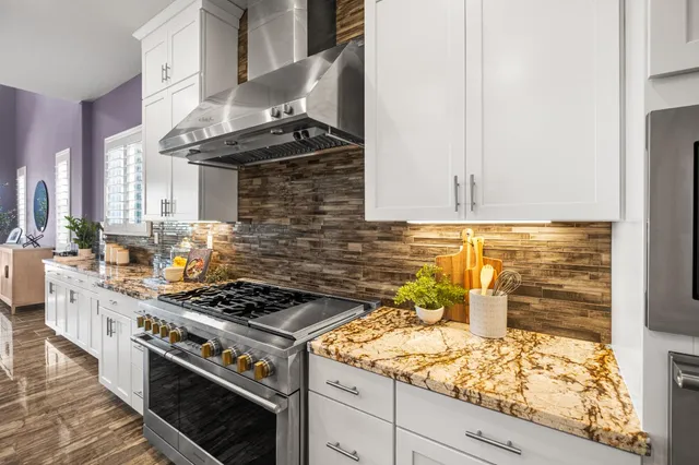 a kitchen with granite countertop white cabinets and refrigerator