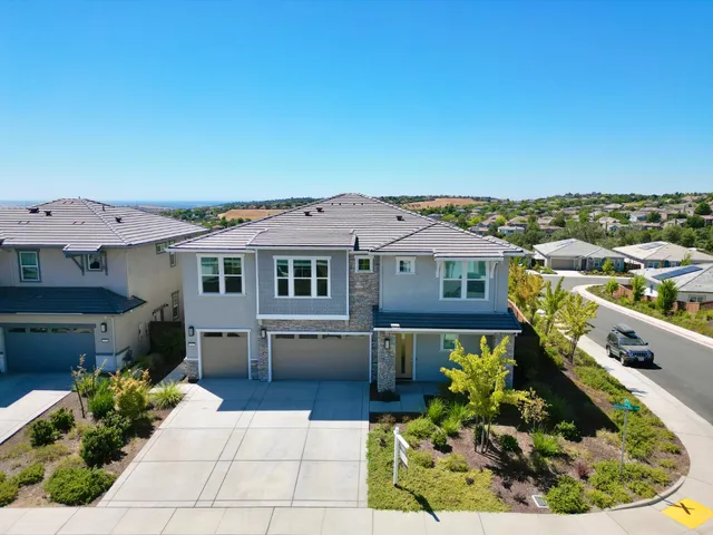 an aerial view of a house with a garden and lake view