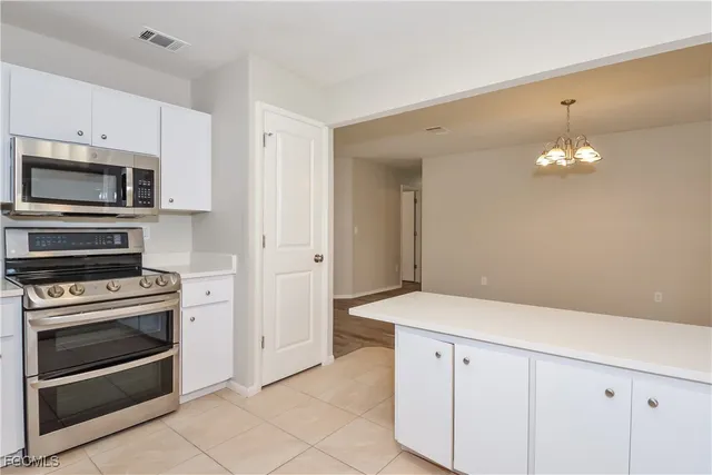 a kitchen with granite countertop cabinets stainless steel appliances and wooden floor