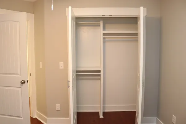 a view of walk in closet with empty racks