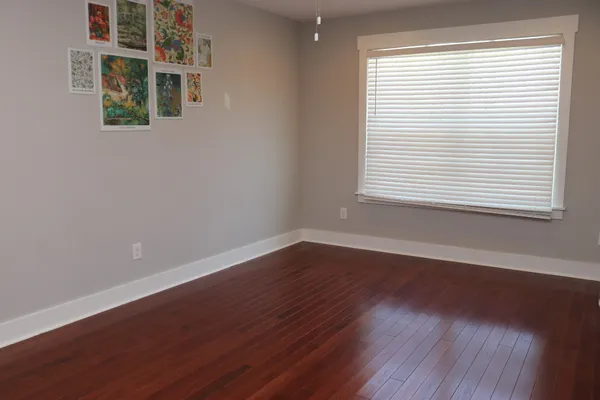 an empty room with wooden floor and a window
