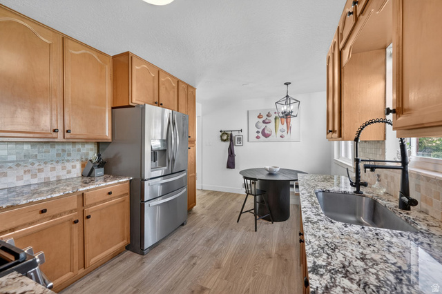 66 South 425 West Bountiful, UT 84010 - Photo 9 of 25 Kitchen featuring light wood cabinetry, granite-style countertops, mosaic tile backsplash, and stainless steel appliances