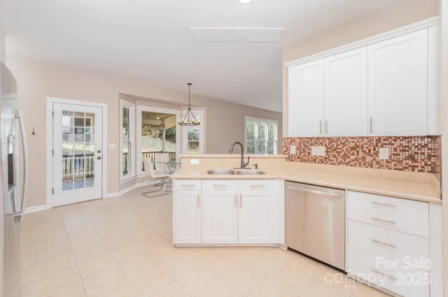 a kitchen with granite countertop white cabinets and white appliances