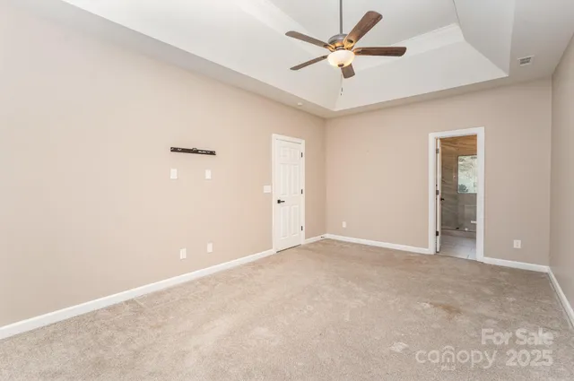an empty room with closet and a ceiling fan