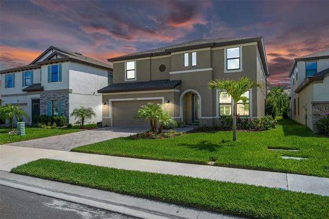 a front view of a house with a yard and garage