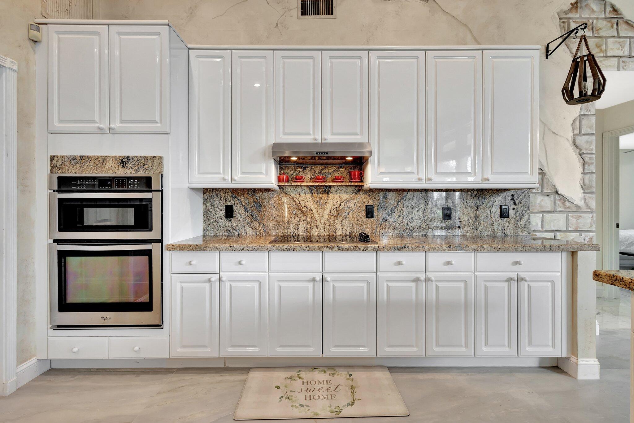 19236 Bay Leaf Court Boca Raton, FL 33498 - Photo 21 of 100 a kitchen with stainless steel appliances granite countertop a stove a microwave and a white cabinets