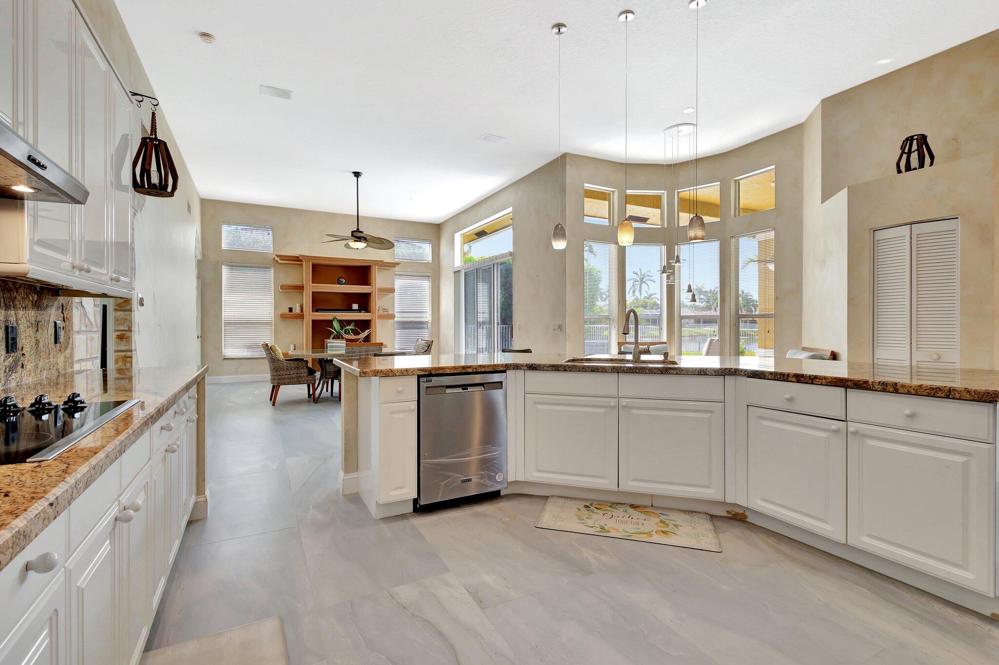 19236 Bay Leaf Court Boca Raton, FL 33498 - Photo 22 of 100 a large white kitchen with a large window and stainless steel appliances