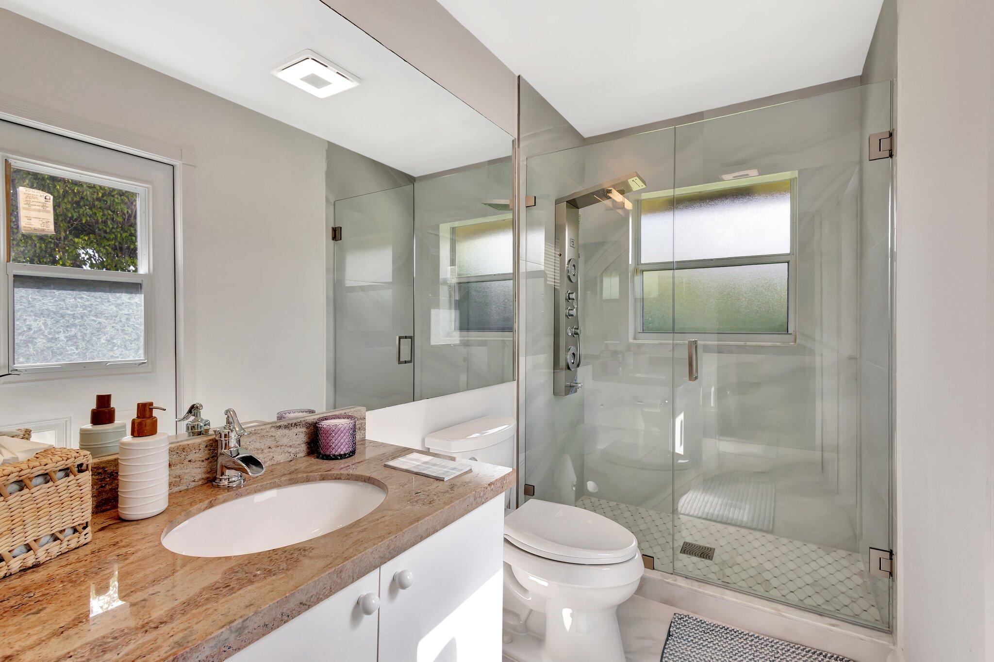 19236 Bay Leaf Court Boca Raton, FL 33498 - Photo 53 of 100 a bathroom with a granite countertop sink toilet mirror and shower