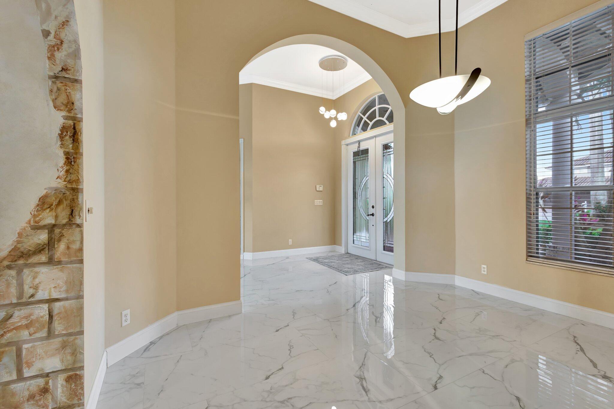 19236 Bay Leaf Court Boca Raton, FL 33498 - Photo 9 of 100 a view of a hallway with windows and chandelier