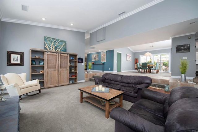 a living room with furniture and a kitchen area