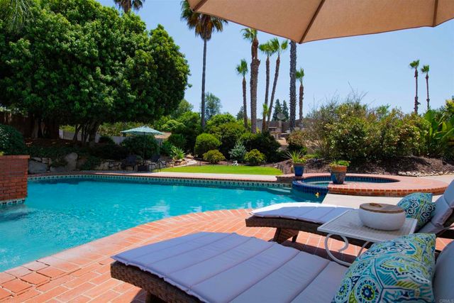 a view of a backyard with couches plants and swimming pool