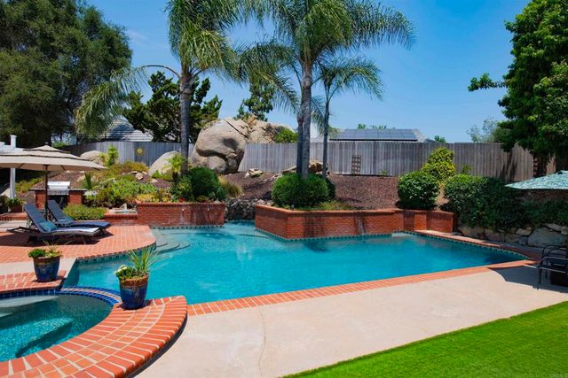 swimming pool view with a seating space and a garden view
