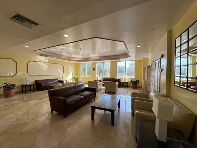 a living room with furniture potted plant and a large window