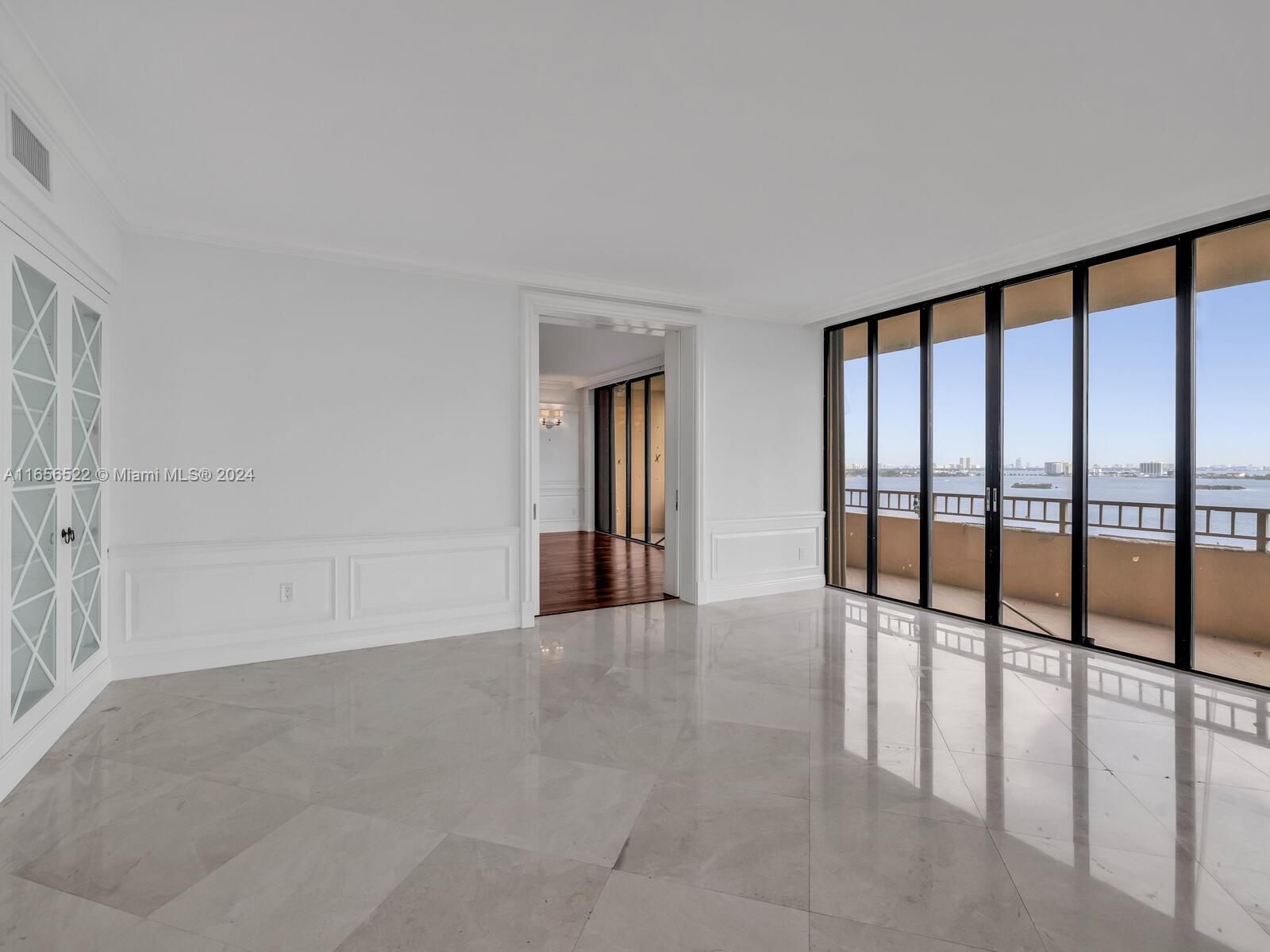 11113 Biscayne Boulevard, Unit PH5 Miami, FL 33181 - Photo 19 of 58 wooden floor in an empty room with a window