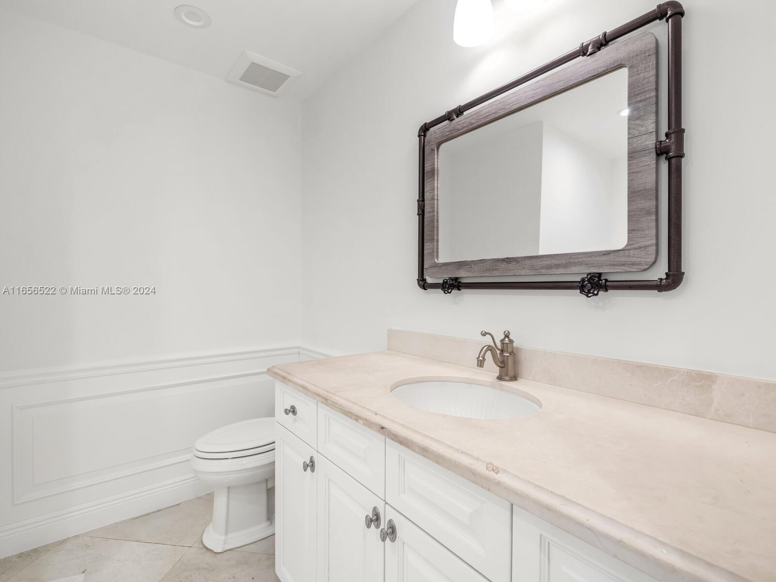 11113 Biscayne Boulevard, Unit PH5 Miami, FL 33181 - Photo 20 of 58 a bathroom with a toilet sink and mirror