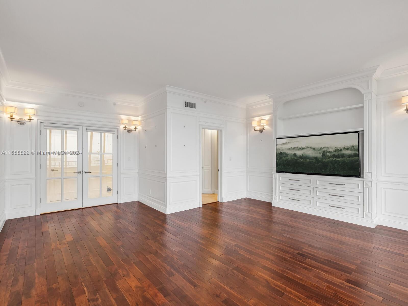 11113 Biscayne Boulevard, Unit PH5 Miami, FL 33181 - Photo 22 of 58 a view of an empty room with wooden floor and a window