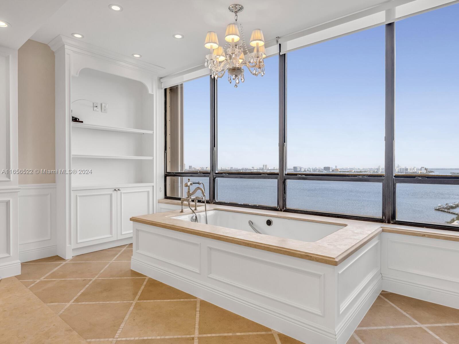 11113 Biscayne Boulevard, Unit PH5 Miami, FL 33181 - Photo 37 of 58 a spacious bathroom with a sink a large mirror and a shower