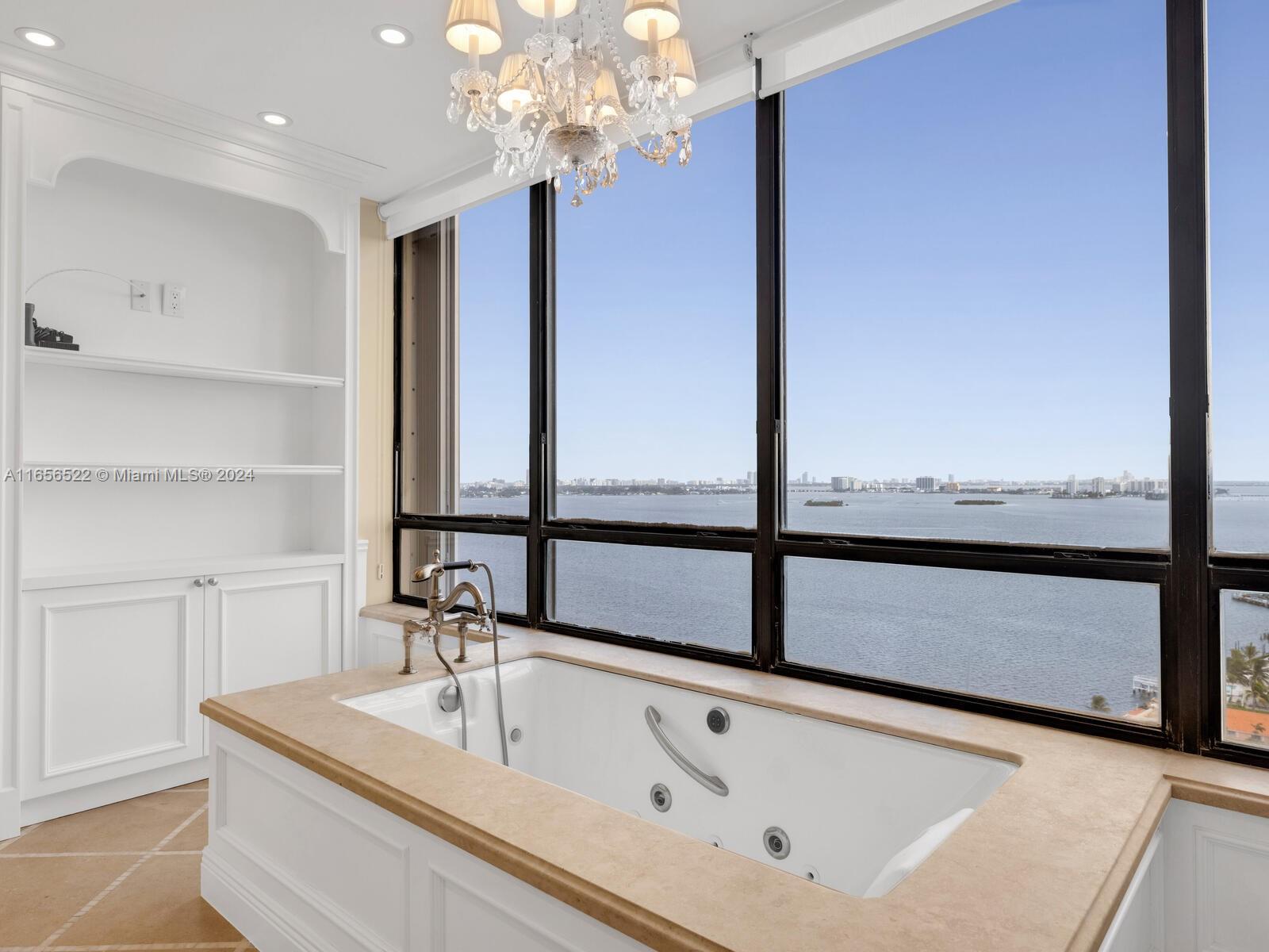 11113 Biscayne Boulevard, Unit PH5 Miami, FL 33181 - Photo 38 of 58 a bathroom with a sink and a large mirror