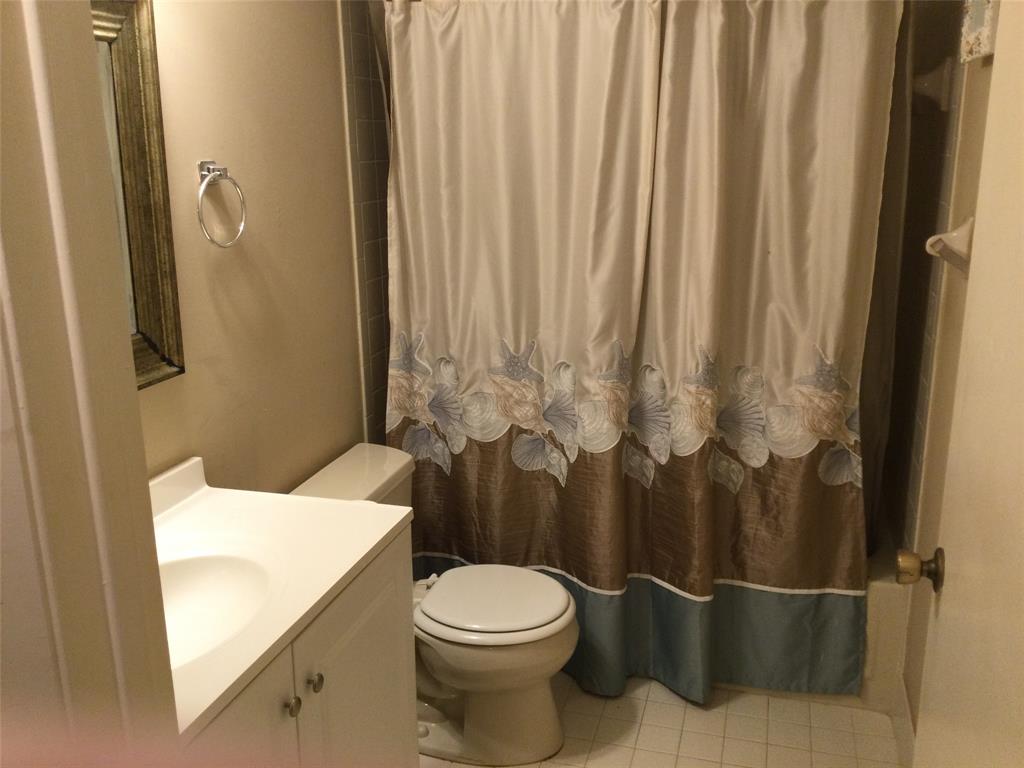 2240 Southwest 92nd Terrace, Unit 2402 Davie, FL 33324 - Photo 7 of 9 a white toilet sitting next to a shower curtain