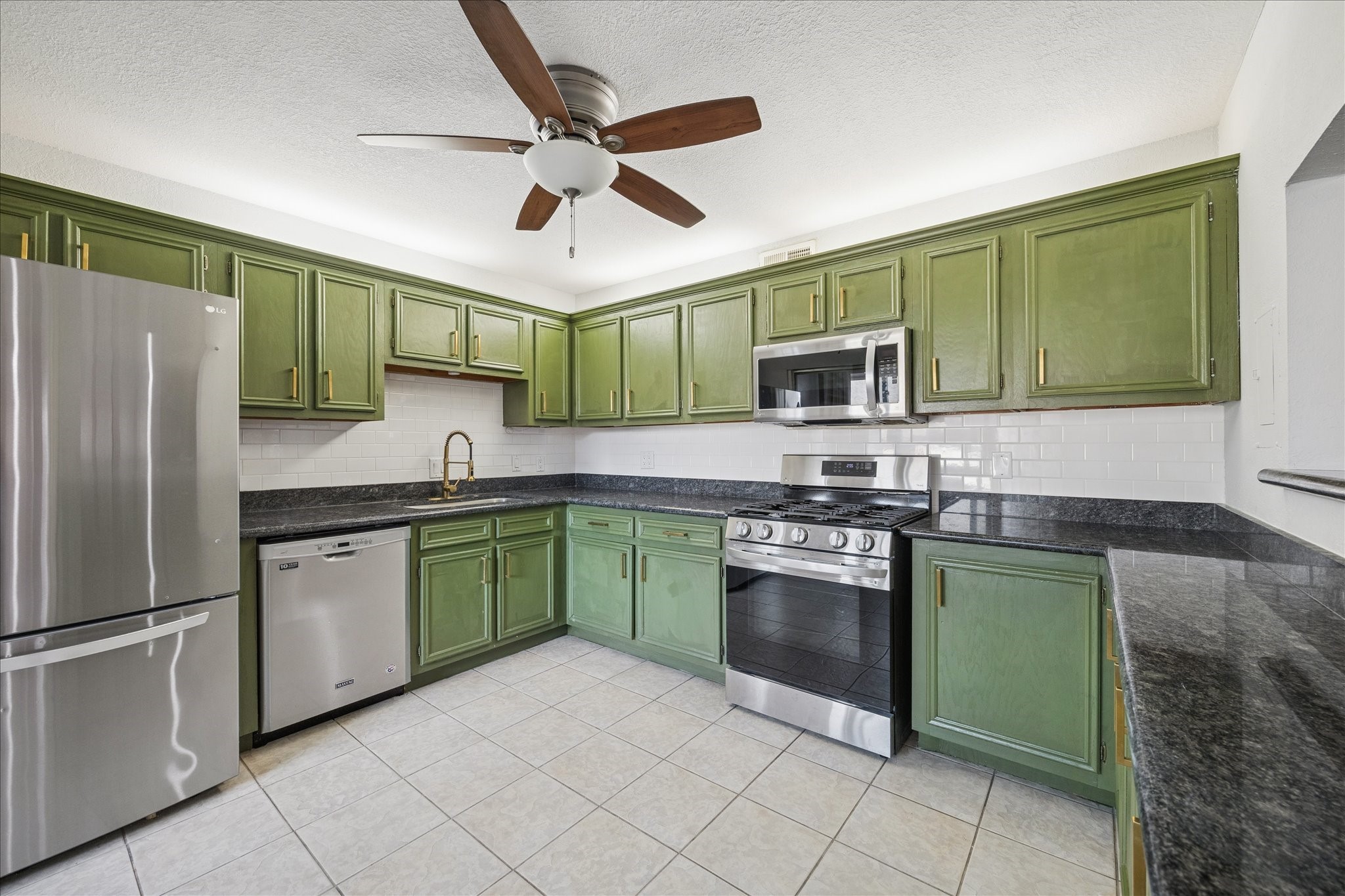 6304 Crab Orchard Road, Unit 6304 Houston, TX 77057 - Photo 5 of 23 A distinctive kitchen highlighted by artistic green cabinetry, gas cooking, and stainless-steel appliances, offering both style and functionality—all appliances included.