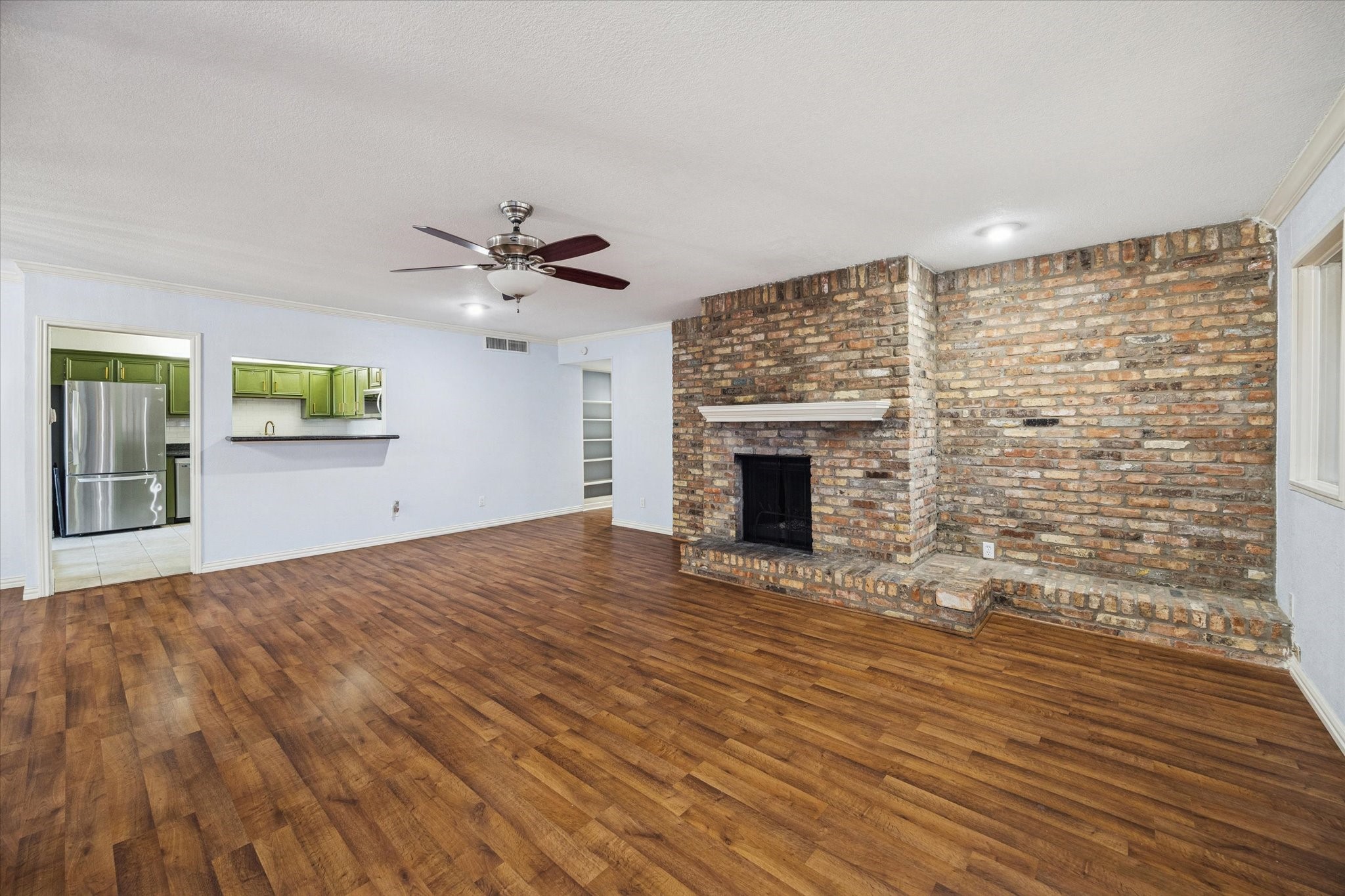 6304 Crab Orchard Road, Unit 6304 Houston, TX 77057 - Photo 9 of 23 The living room is highlighted by durable LVP flooring and a central brick fireplace.