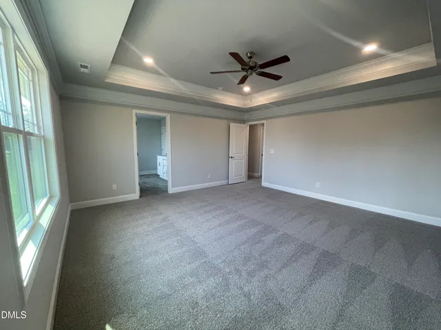 an empty room with a window and a ceiling fan