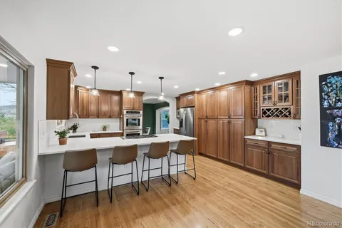 a kitchen with stainless steel appliances a dining table chairs stove refrigerator and cabinets