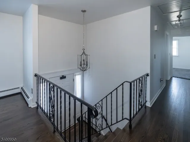 a view of a hallway with wooden floor and entryway