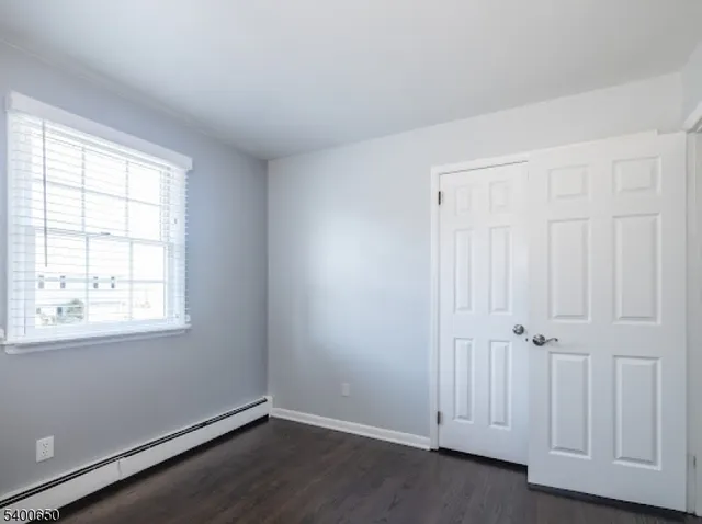 an empty room with wooden floor and window